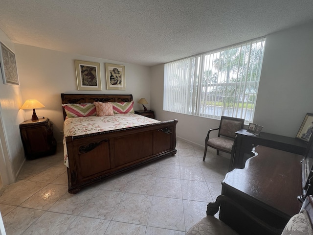 bedroom featuring light tile patterned floors and a textured ceiling