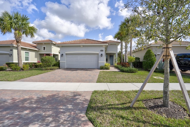 mediterranean / spanish-style house featuring a front yard and a garage