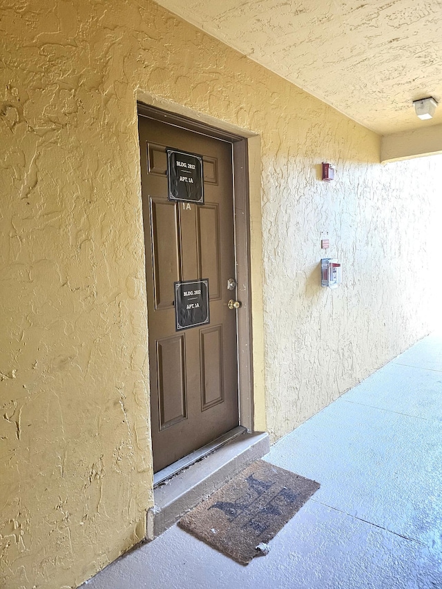 doorway to property featuring stucco siding