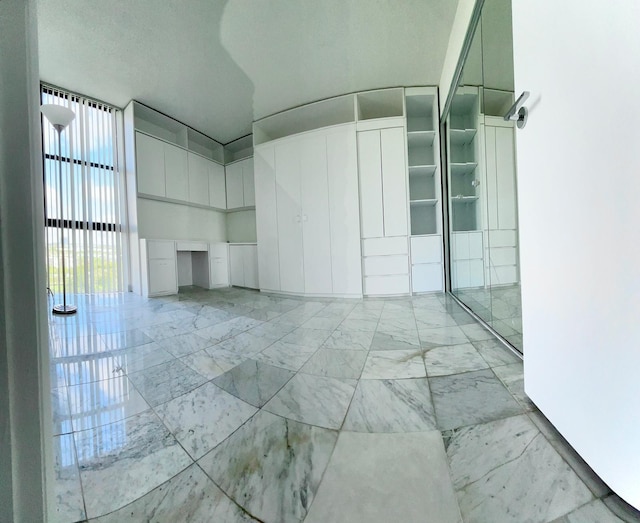 spare room featuring marble finish floor