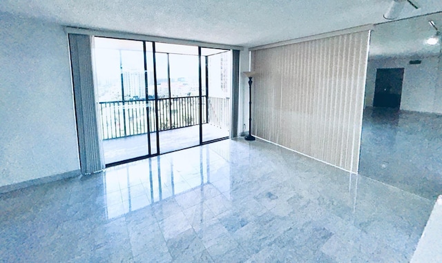 empty room with a wall of windows and a textured ceiling