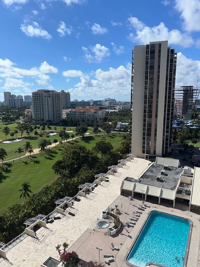 community pool with a patio area and a city view