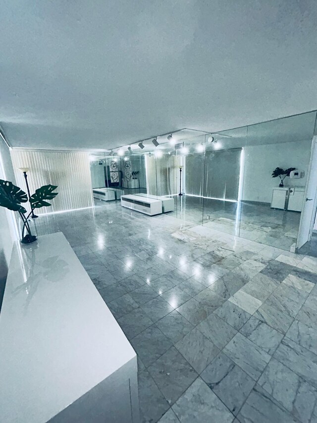 interior space featuring marble finish floor and a textured ceiling