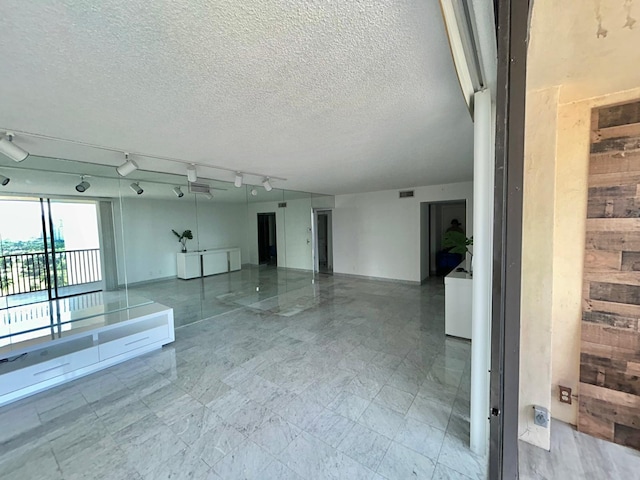 unfurnished room featuring rail lighting, visible vents, and a textured ceiling
