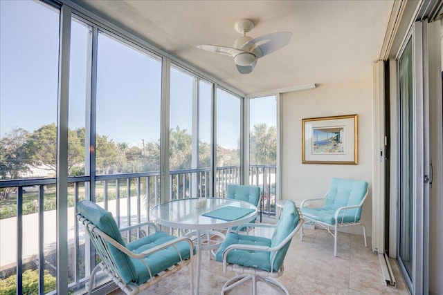 sunroom featuring ceiling fan and plenty of natural light