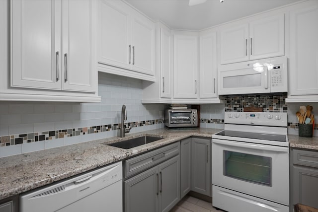 kitchen with sink, white appliances, and white cabinetry