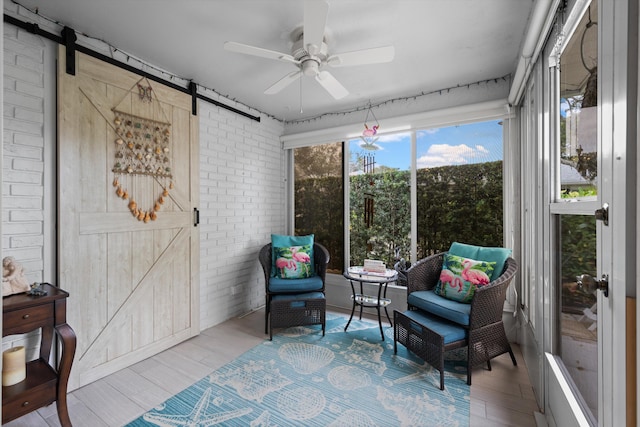 10137 S 42nd Ave S, Boynton Beach, FL 33436 - sitting room featuring brick wall, wood finished floors, ceiling fan, and a barn door