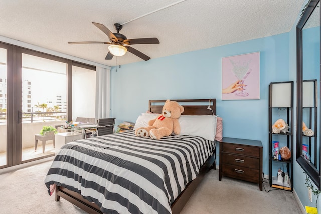 carpeted bedroom featuring a textured ceiling, ceiling fan, access to exterior, and floor to ceiling windows