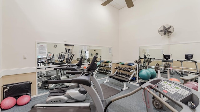 exercise room with a towering ceiling and ceiling fan