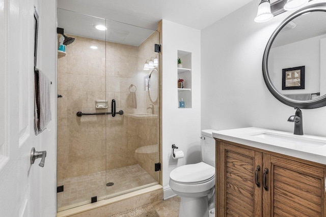 bathroom with a shower stall, toilet, and vanity