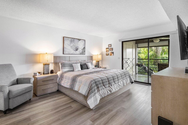 bedroom with light wood-type flooring, access to exterior, and a textured ceiling