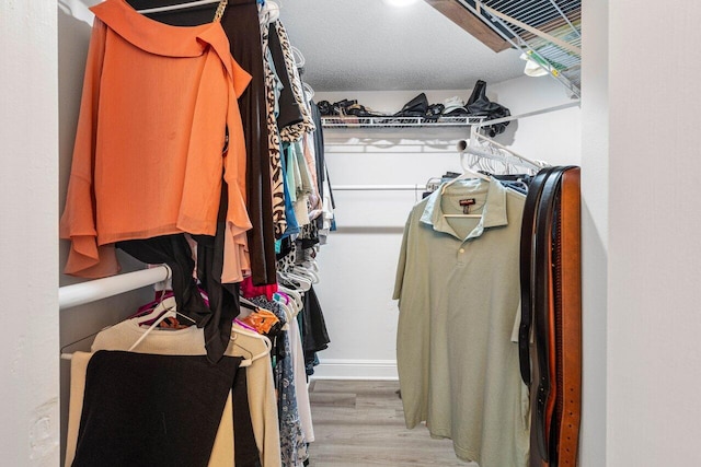 walk in closet with wood finished floors