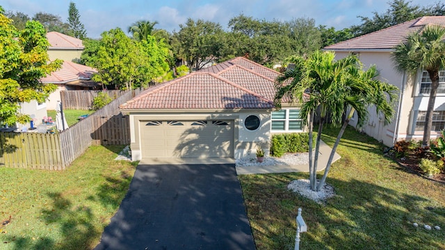 mediterranean / spanish-style home featuring a front lawn, a tiled roof, fence, and stucco siding