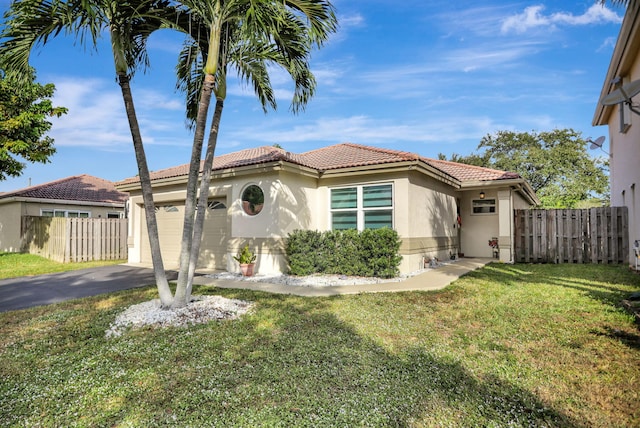 mediterranean / spanish-style home featuring aphalt driveway, stucco siding, a garage, and fence