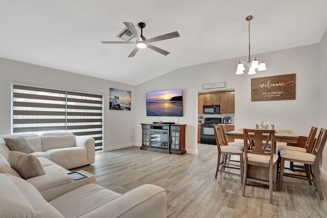 living room featuring light wood-type flooring, lofted ceiling, baseboards, and ceiling fan with notable chandelier