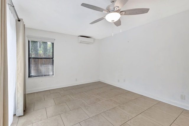 spare room with a ceiling fan, a wall unit AC, and baseboards