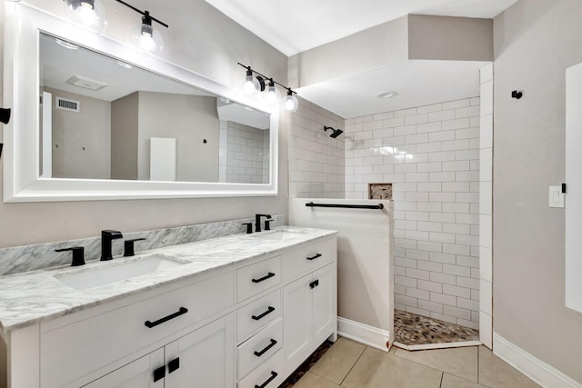 bathroom with double vanity, visible vents, a sink, tile patterned flooring, and walk in shower