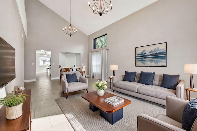 living room with light tile patterned floors, baseboards, high vaulted ceiling, and ceiling fan with notable chandelier