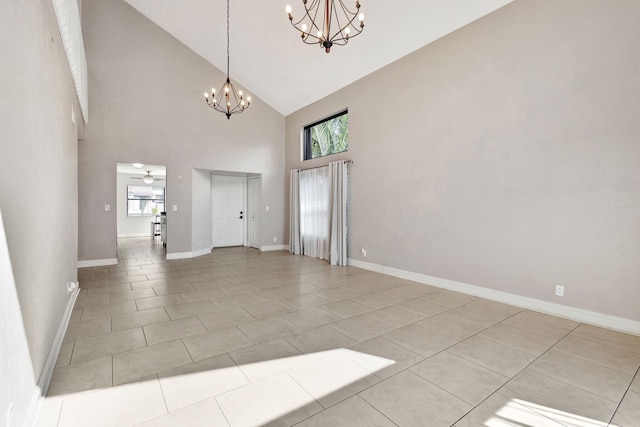 interior space featuring light tile patterned flooring, baseboards, high vaulted ceiling, and ceiling fan with notable chandelier