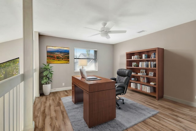 home office with baseboards, visible vents, ceiling fan, and light wood finished floors