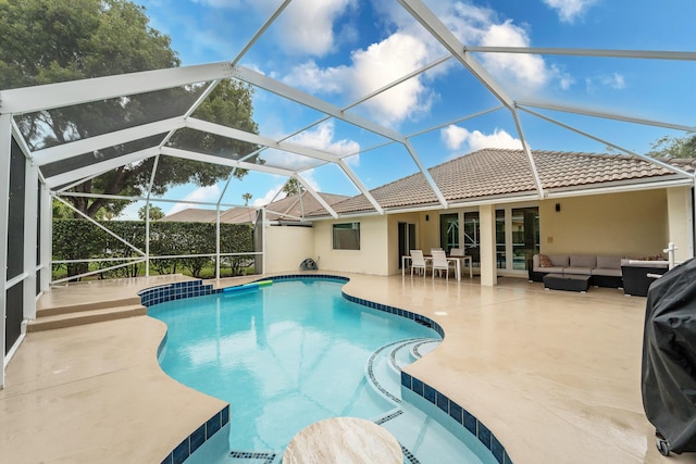 outdoor pool with glass enclosure, a patio, and outdoor lounge area