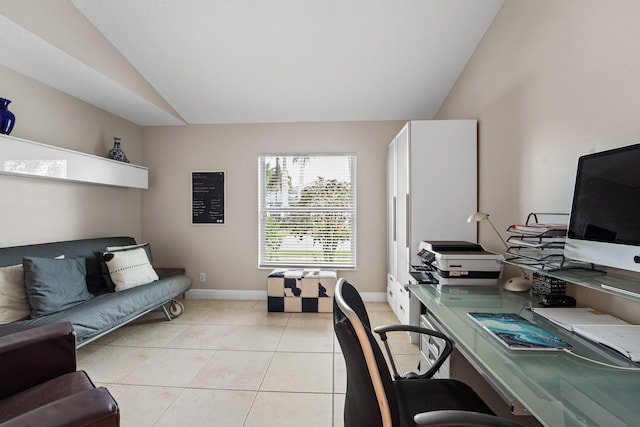 office space with vaulted ceiling, baseboards, and light tile patterned floors