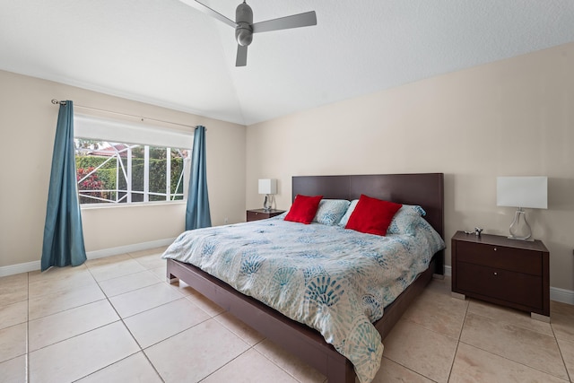 bedroom with light tile patterned floors, ceiling fan, baseboards, and vaulted ceiling