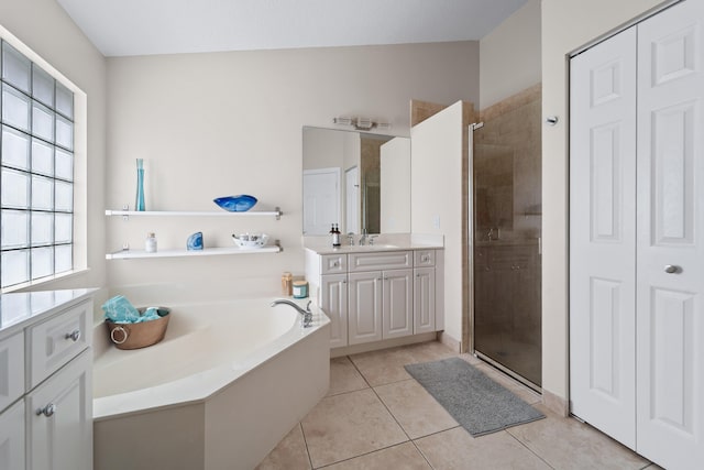 bathroom with a closet, tile patterned flooring, vanity, and a stall shower