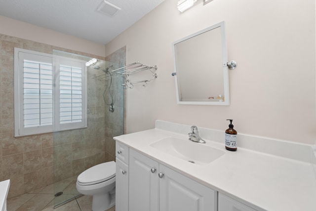 bathroom with visible vents, toilet, tile patterned floors, vanity, and a walk in shower