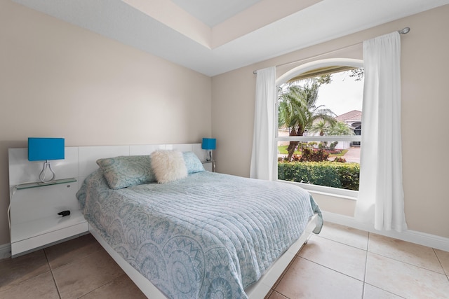 bedroom with multiple windows, baseboards, and light tile patterned flooring