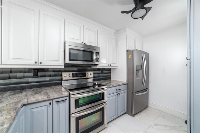 kitchen with baseboards, white cabinets, decorative backsplash, appliances with stainless steel finishes, and marble finish floor