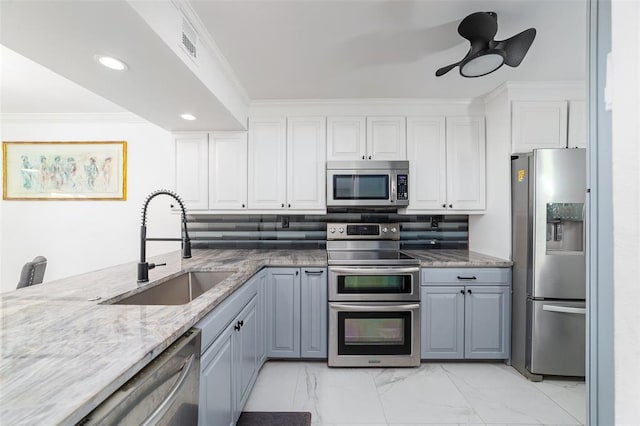 kitchen with stainless steel appliances, a sink, visible vents, marble finish floor, and crown molding