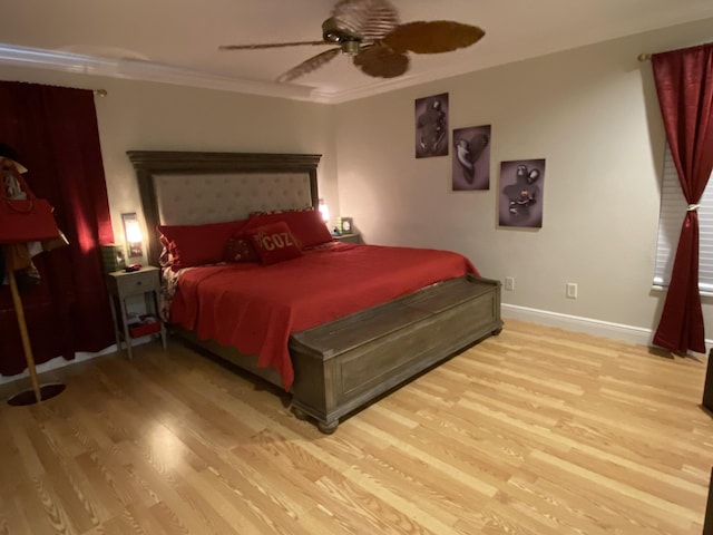 bedroom with light wood-style floors, crown molding, baseboards, and ceiling fan