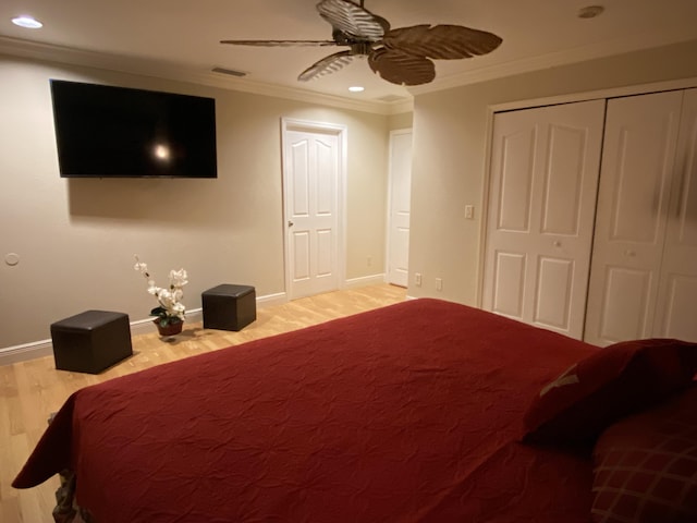 bedroom featuring baseboards, wood finished floors, and crown molding