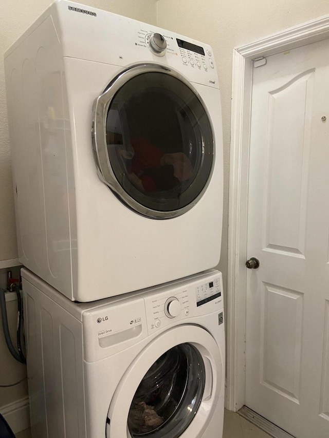 clothes washing area featuring laundry area and stacked washing maching and dryer