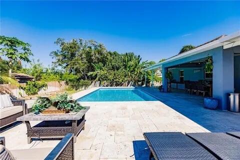 pool with a patio, fence, and an outdoor living space