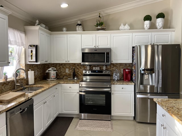 kitchen featuring stainless steel appliances, white cabinetry, a sink, and crown molding