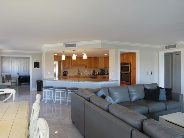 living area featuring crown molding, baseboards, and light tile patterned flooring
