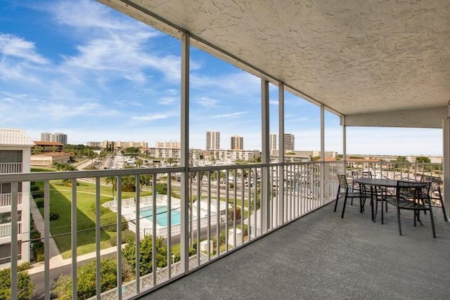 balcony with a view of city and view of pool