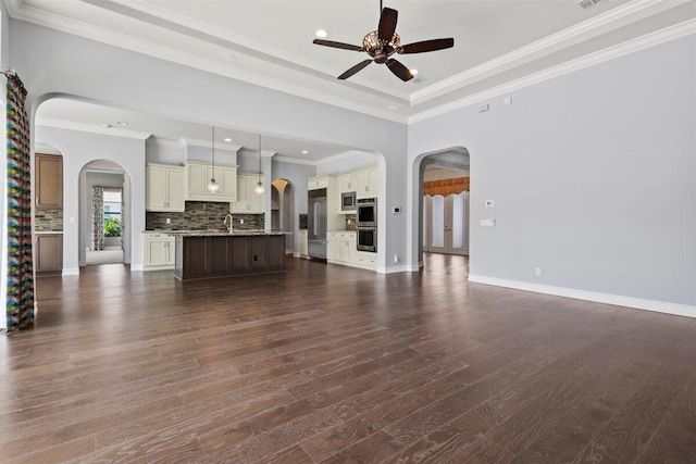 unfurnished living room featuring baseboards, arched walkways, ceiling fan, dark wood-style flooring, and a sink