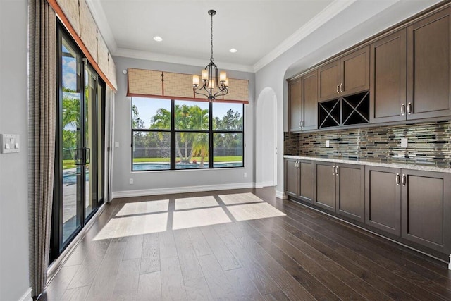 kitchen featuring a chandelier, dark wood-style floors, backsplash, and crown molding