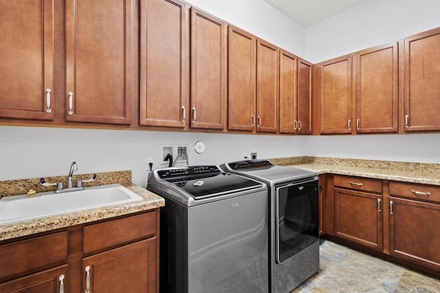 laundry area featuring cabinet space, a sink, and separate washer and dryer