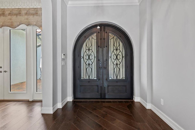 entrance foyer with baseboards, arched walkways, dark wood-style floors, crown molding, and french doors