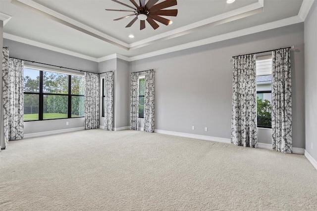 carpeted empty room with crown molding, recessed lighting, a raised ceiling, a ceiling fan, and baseboards