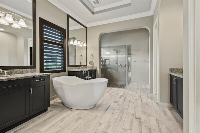 full bath with a freestanding bath, ornamental molding, a stall shower, and wood finished floors