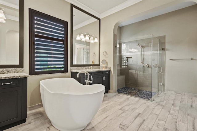 full bath featuring a soaking tub, a shower stall, crown molding, and wood finished floors