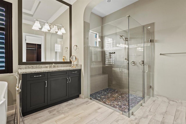 full bathroom with a shower stall, ornamental molding, wood finished floors, and vanity