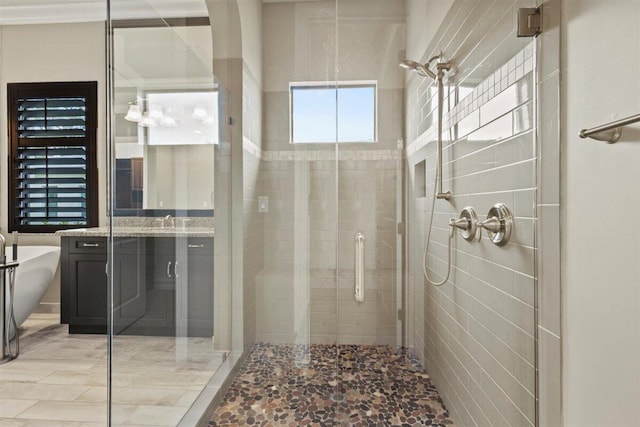 bathroom with a stall shower, a soaking tub, and vanity