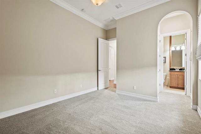 unfurnished bedroom featuring light carpet, baseboards, visible vents, and crown molding