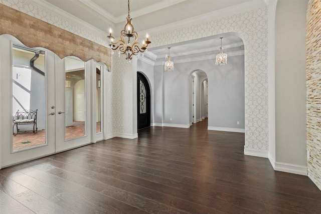 empty room with hardwood / wood-style floors, wallpapered walls, arched walkways, and crown molding